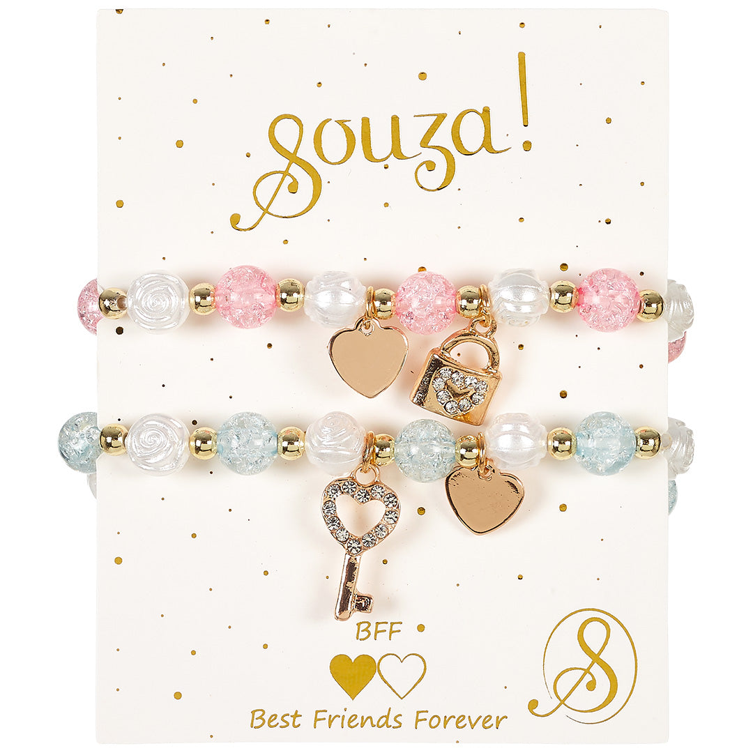 Souza for kids vriendschapsarmbanden met roze, blauwe en witte kralen en gouden bedeltjes van een hart, slot en sleutel, gepresenteerd op de verpakking.