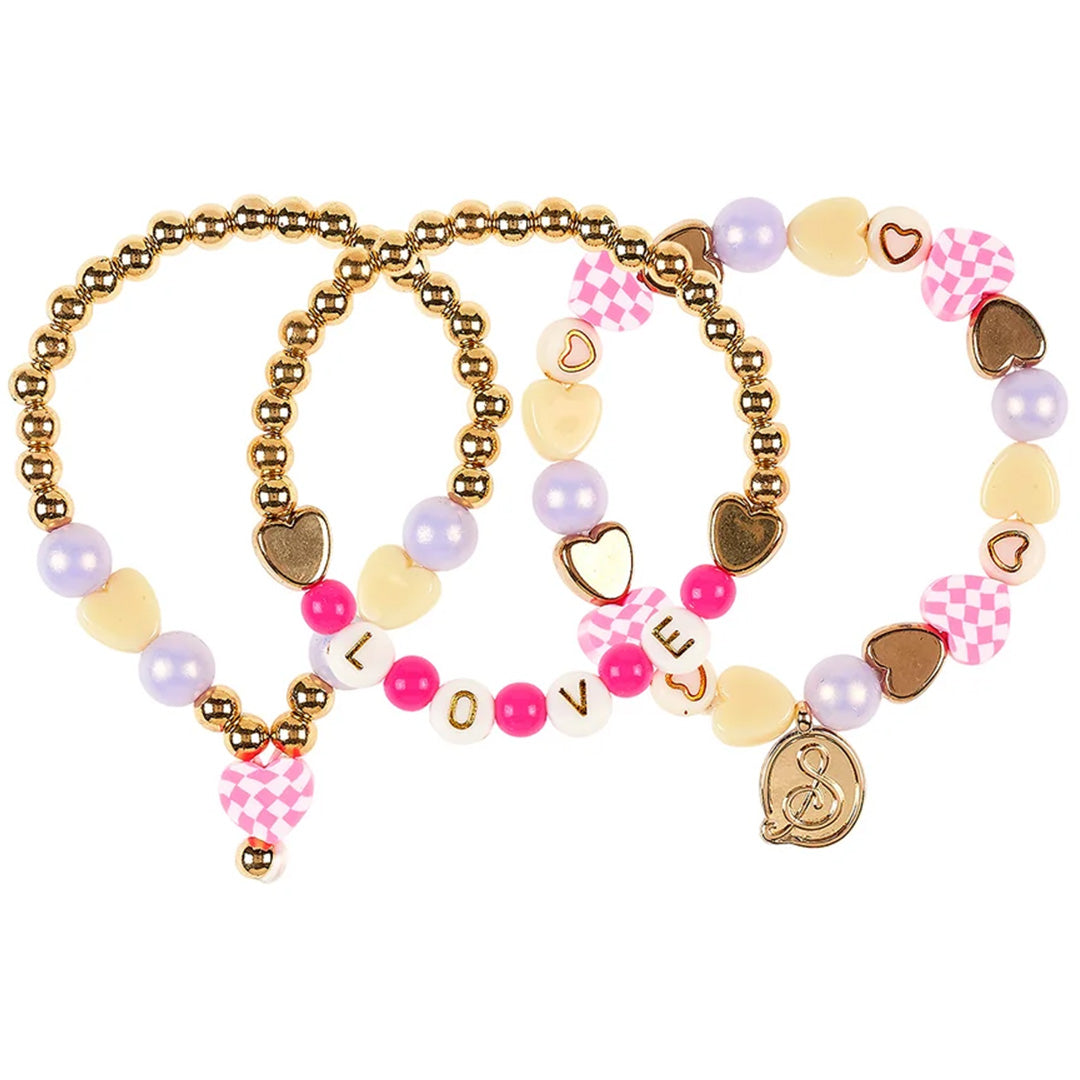 Souza for kids sieradenset met drie kinderarmbanden met goudkleurige, roze, paarse en crèmekleurige kralen, hartjes en de tekst 'LOVE'.