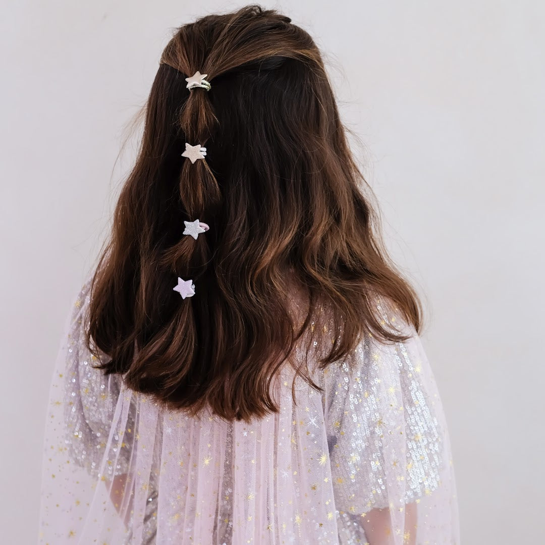 Een kind met lang bruin haar draagt vier mimi & lula haarelastiekjes met sterren, zichtbaar van achteren.