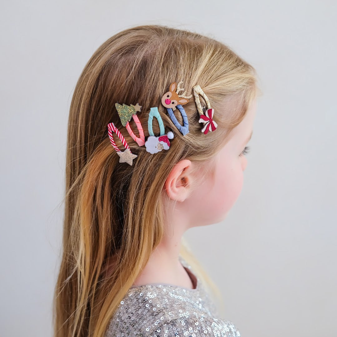 Een meisje met blond haar draagt de kerst haarclipjes, gezien van schuin achteren.
