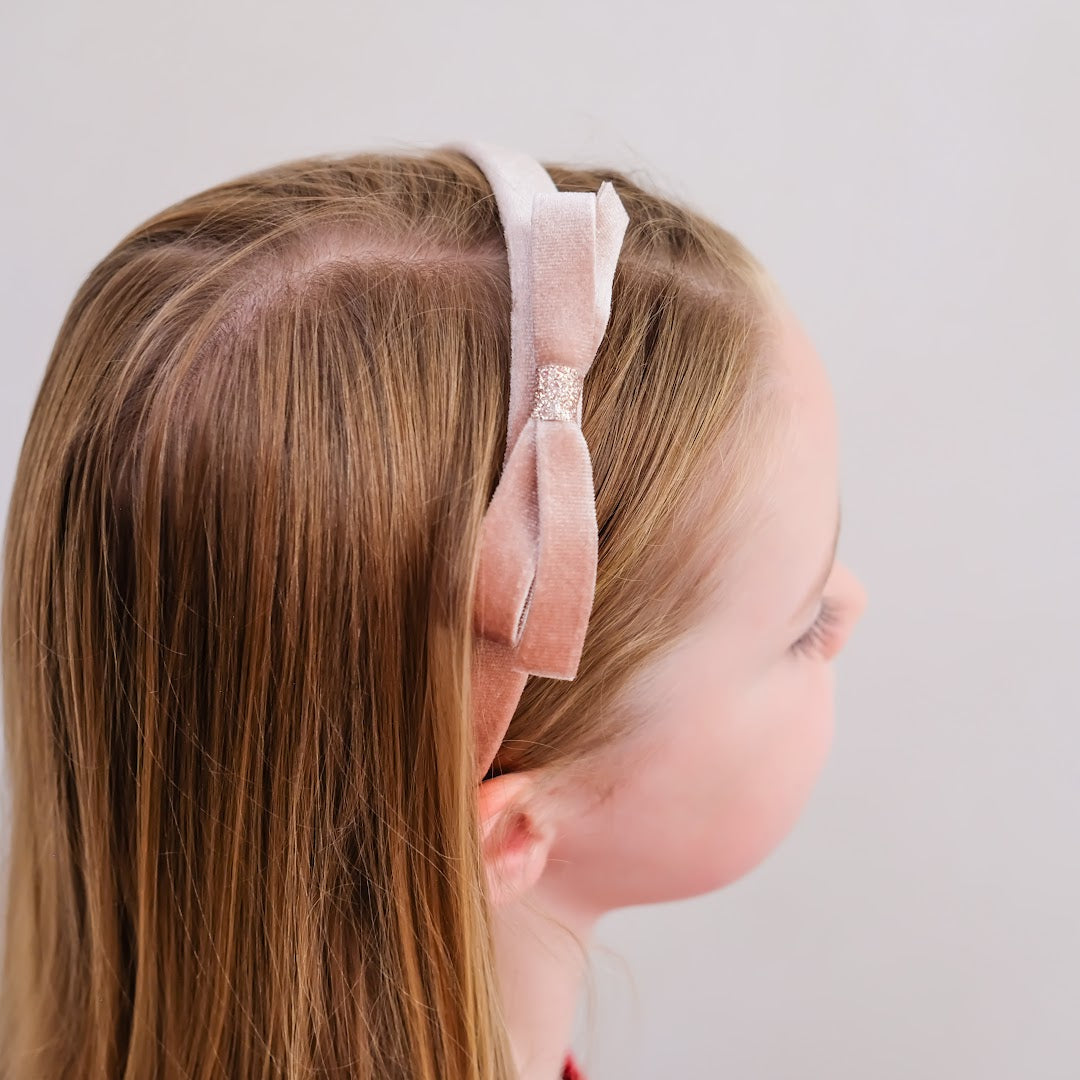 Achteraanzicht van een meisje dat de Mimi & Lula roze fluwelen kinderhaarband draagt.