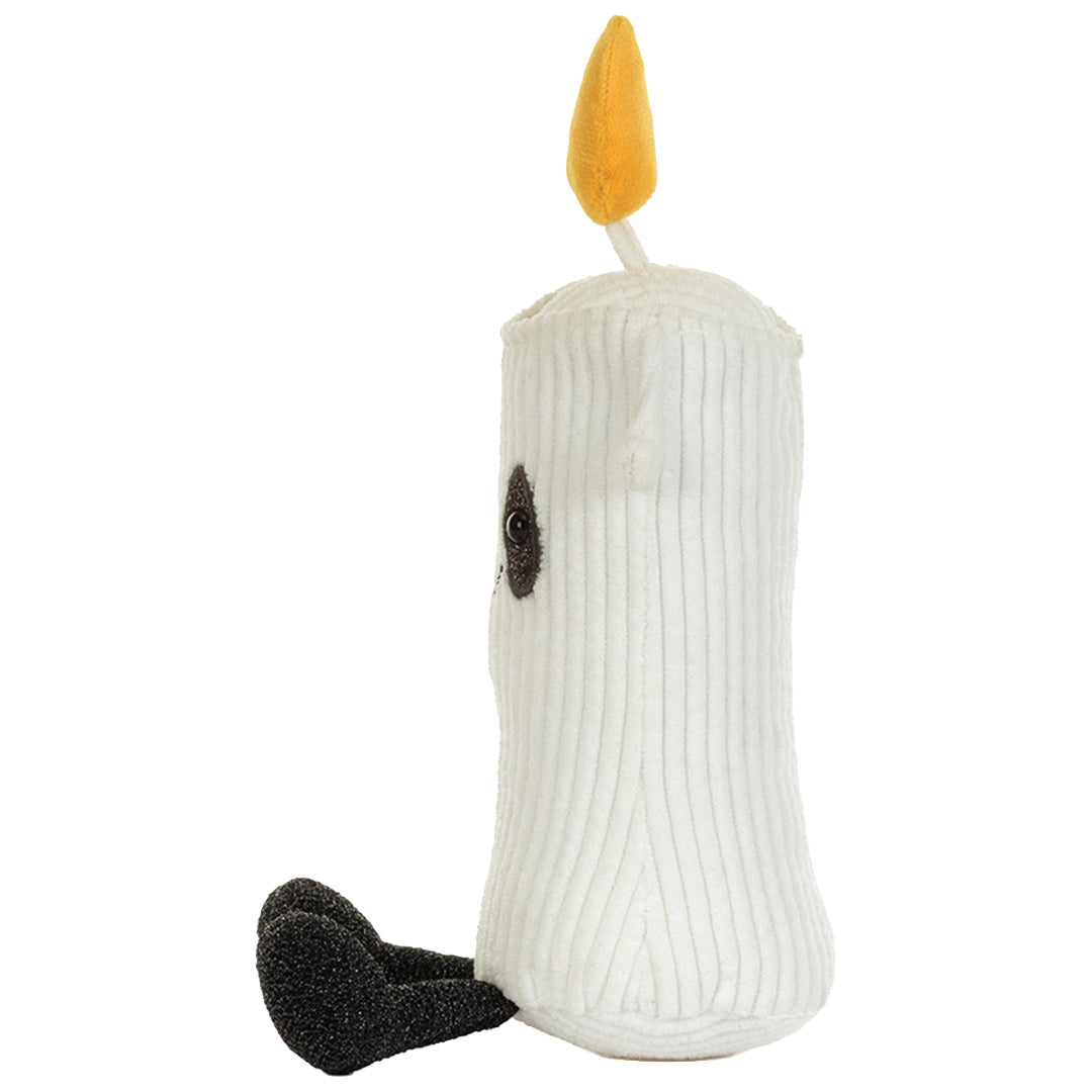 De Jellycat knuffelkaars Flickerty, een wit pluchen kaarsje met gele vlam, zit van de linkerkant gezien.