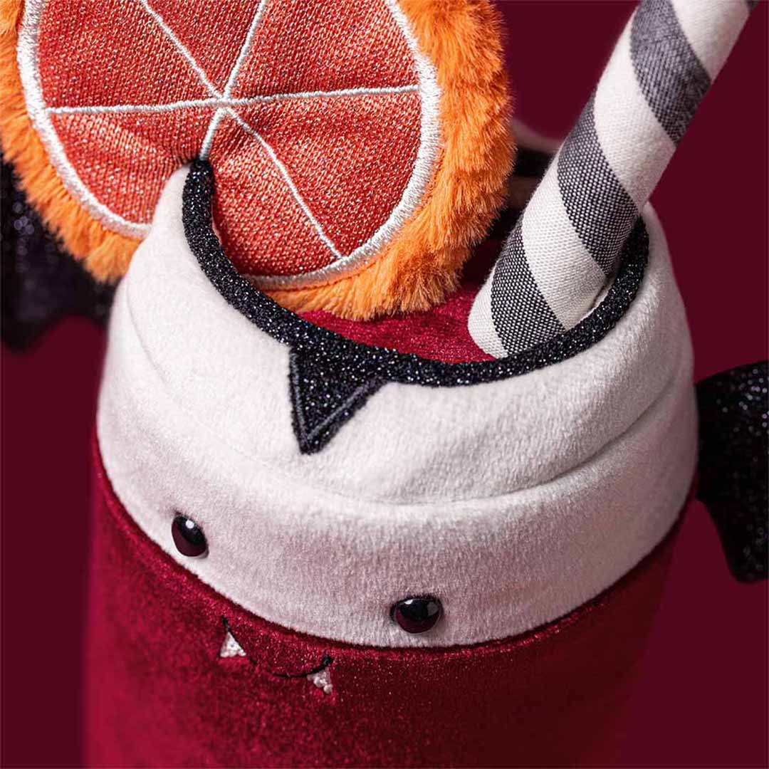 Detail van de Jellycat pluchen knuffelbeker met vampiergezichtje, rietje en sinaasappelschijfje.