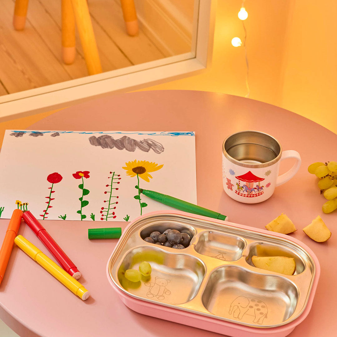 rice rvs vakjesbord in roze houder met fruit, naast een kindertekening en stiften.