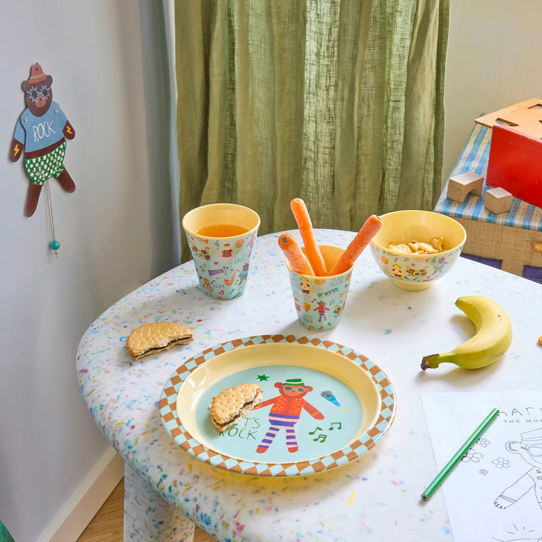 rice kinderkom als onderdeel van een kinderservies met 'music band' patroon op een gedekte tafel.