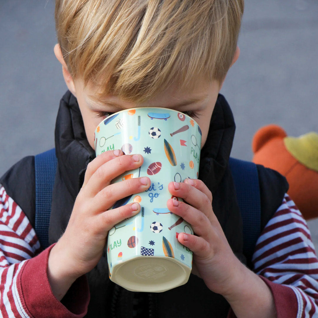 Een kind drinkt uit de rice kinderbeker met sportthema.