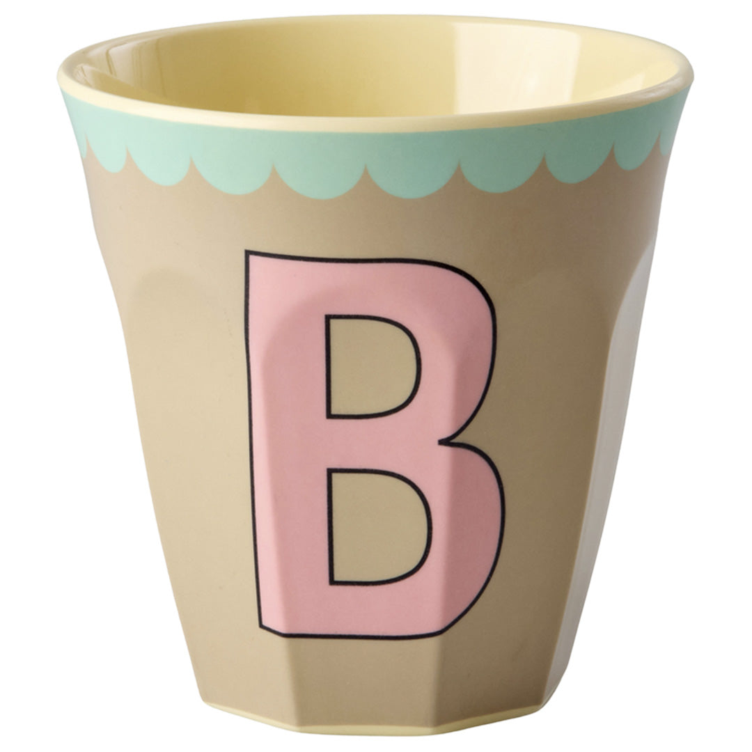 rice plastic beker in beige met een roze letter B en een lichtblauwe rand.