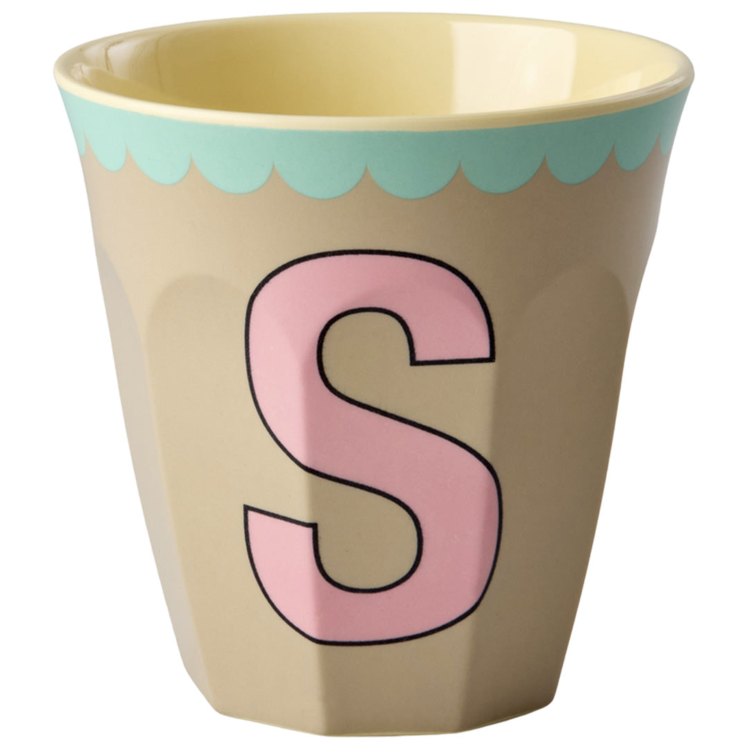 rice alfabetbeker in beige met de roze letter S en een blauwe geschulpte rand.
