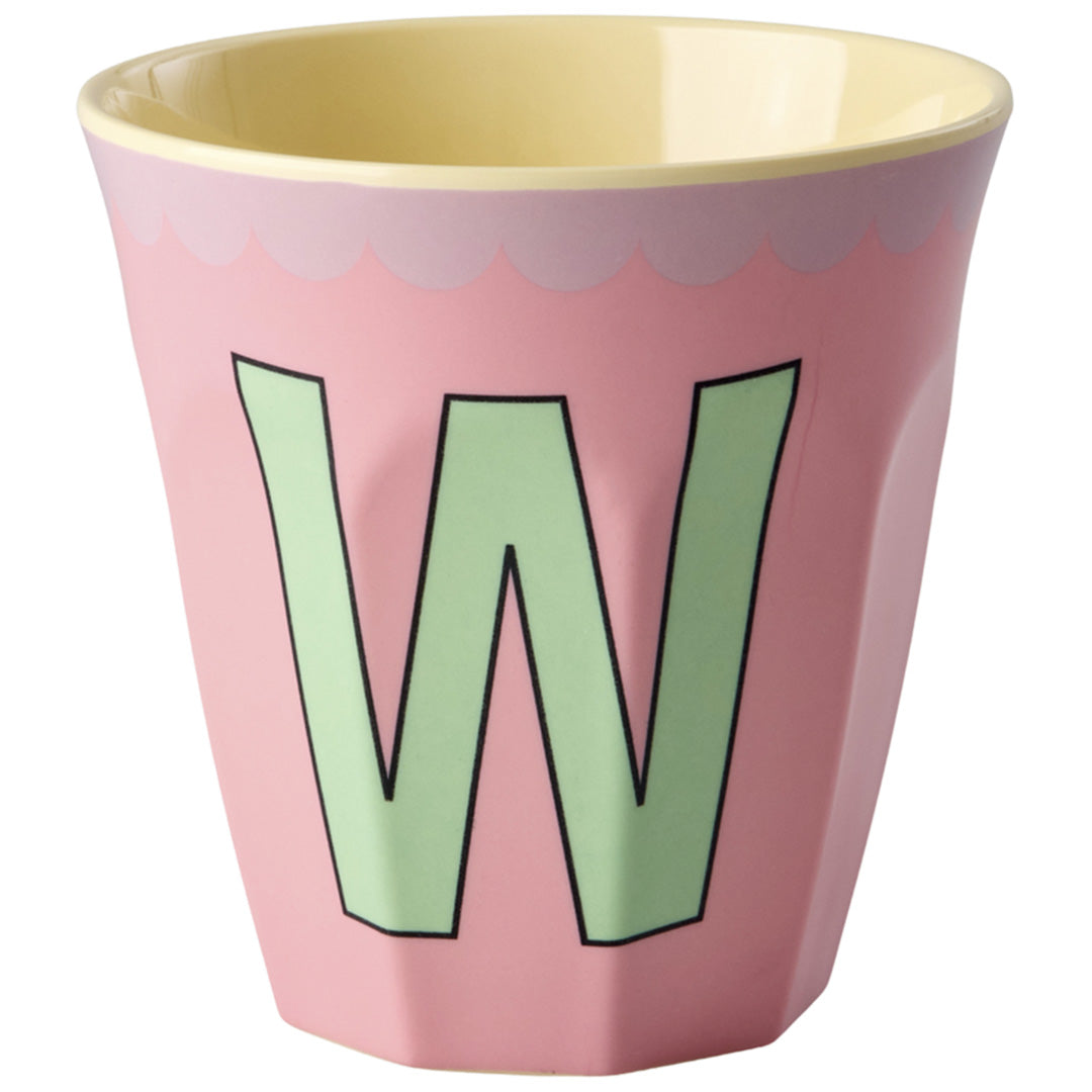 rice roze plastic alfabetbeker met de groene letter W en gele binnenkant.