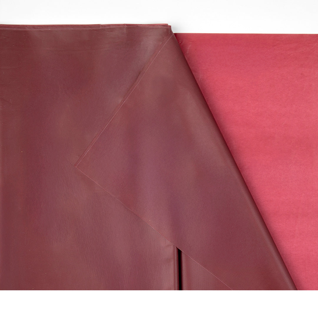 Detail van een gevouwen PartyDeco donkerrood plastic tafelkleed.