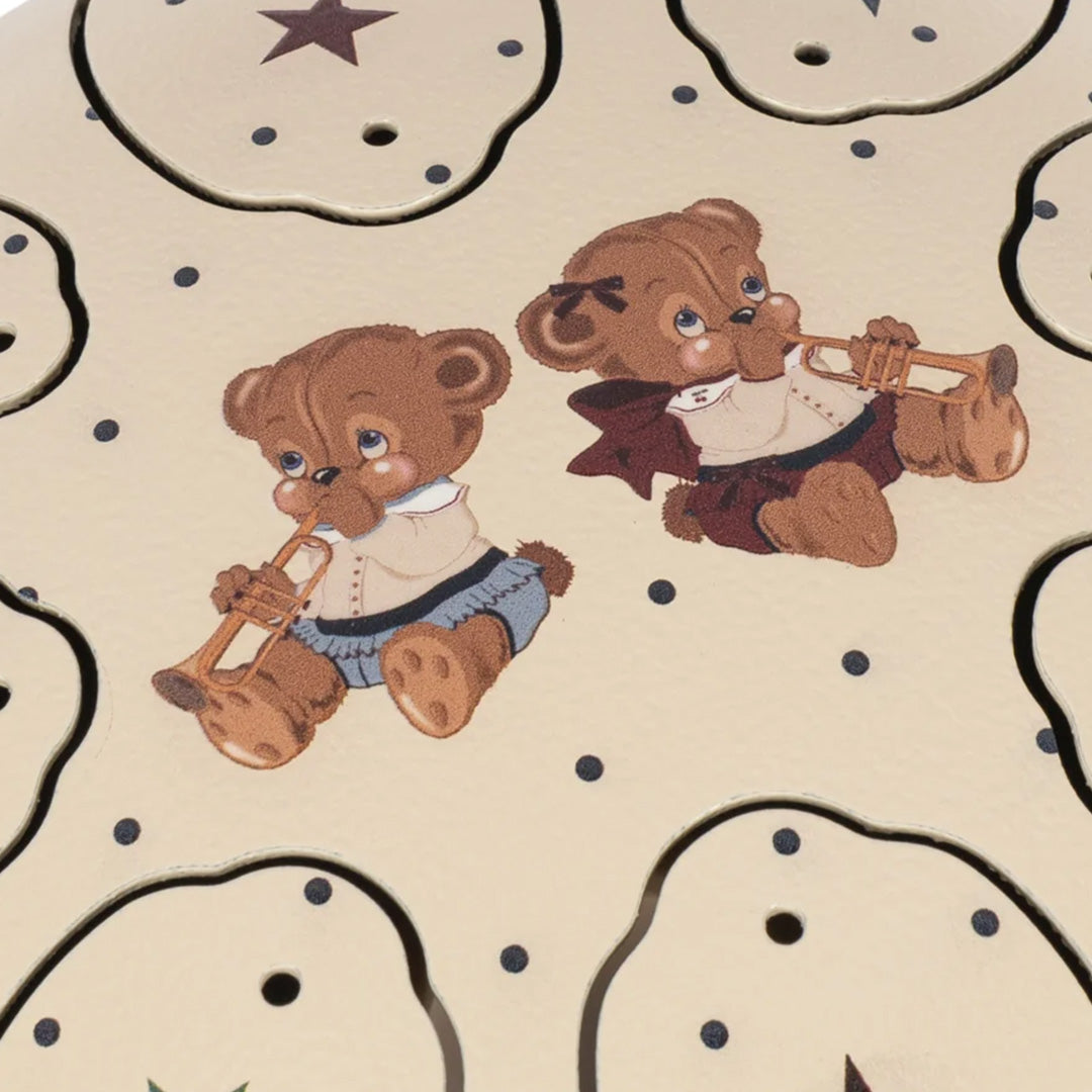 Detail van de houten tongtrommel met twee teddyberen die trompet spelen.
