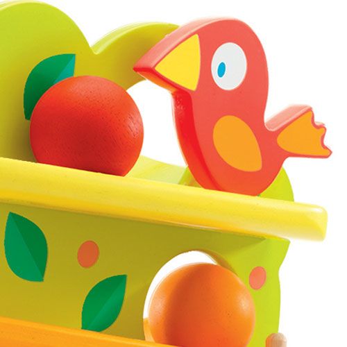 Detail van de houten ballenboom met een rode vogel en een rode bal op een platform.