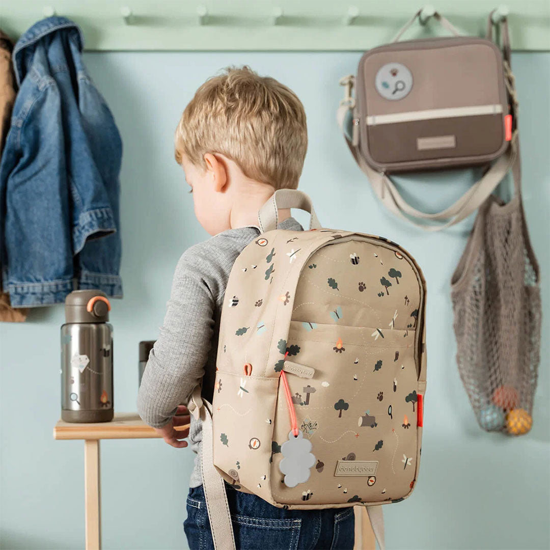 Een kind draagt de Done by Deer kinderrugzak met Tiny Trails patroon op de rug.