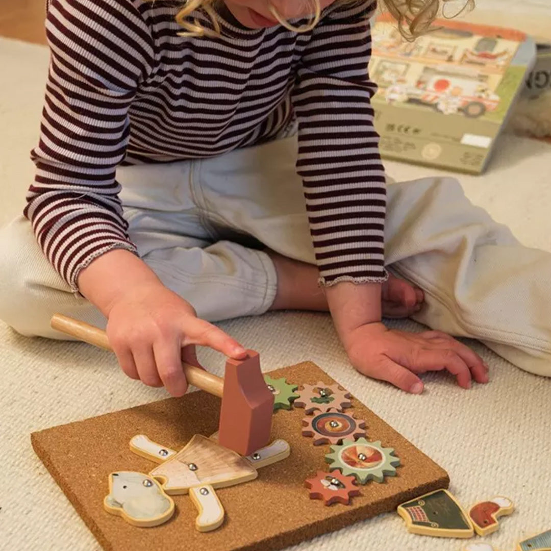 Een kind speelt met het Egmont Toys hamertje tik speelgoed, waarbij een houten dierfiguur op een kurkplaat wordt gehamerd.