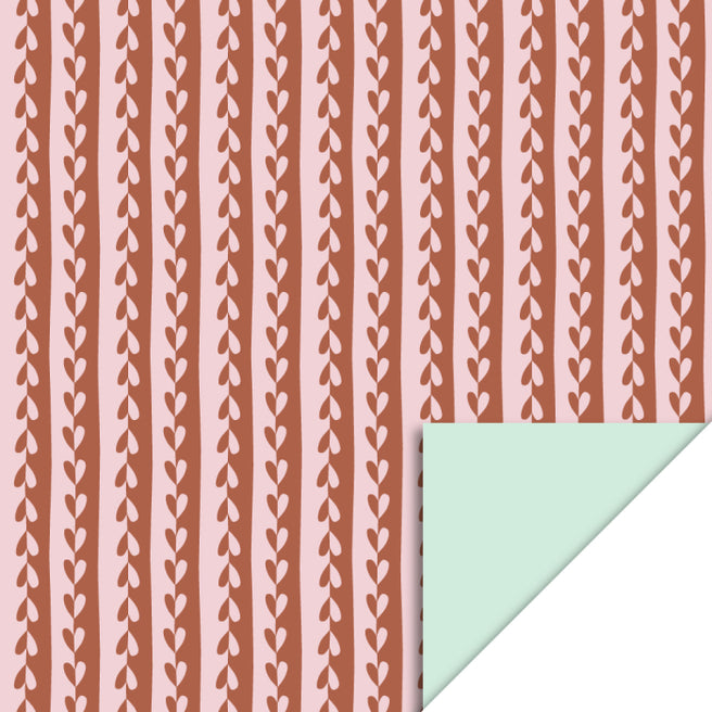 house of products inpakpapier met roze en bruine gestreepte hartenpatroon, met een omgevouwen hoek die de pastel mint achterkant toont.