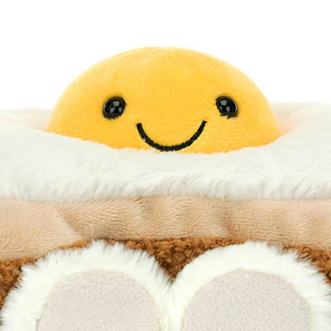 Close-up van het lachende gele ei van de Jellycat knuffel op brood.