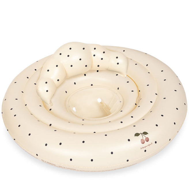 Konges Sløjd baby zwemstoel in beige met zwarte stippen en kersenlogo.