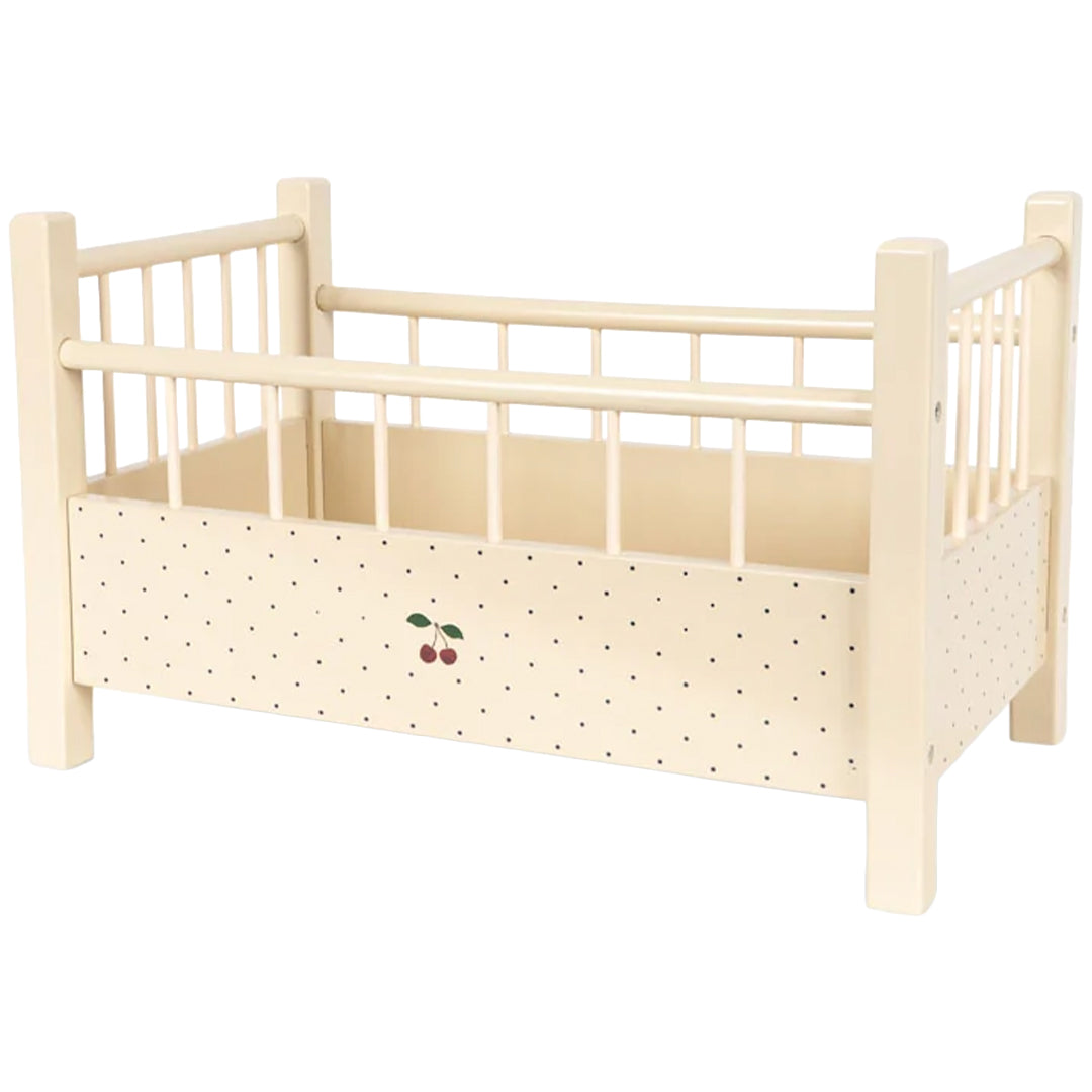 Konges Sløjd houten poppenbed in beige met zwarte stippen en een kersenillustratie.