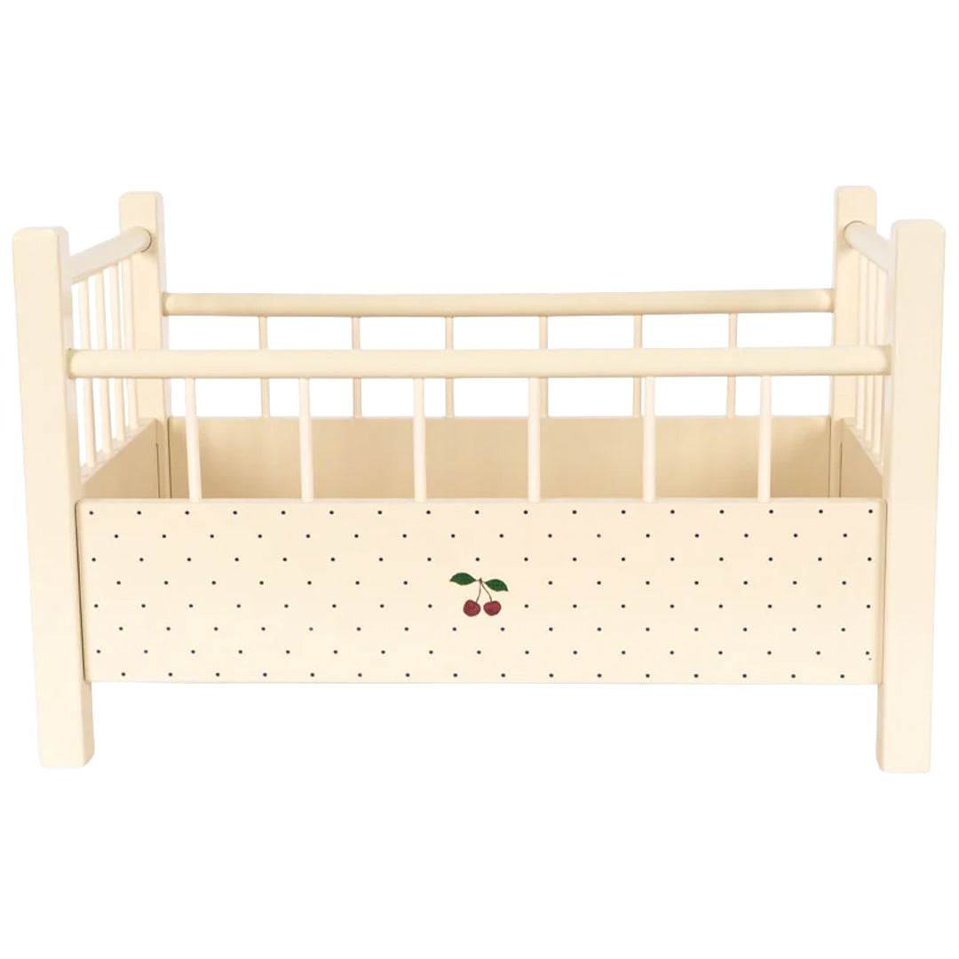 Vooraanzicht van het Konges Sløjd houten poppenbed in beige met zwarte stippen en een kersenillustratie.