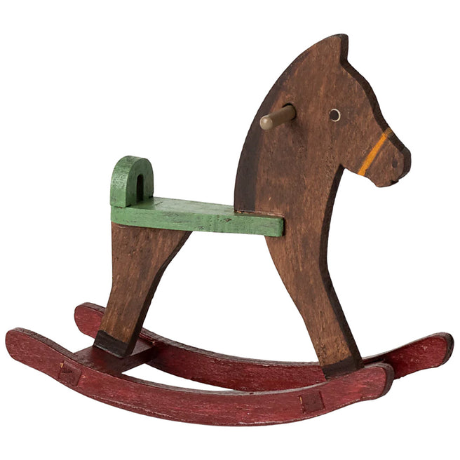 Maileg donkerbruin houten hobbelpaard voor poppenhuizen met groene zitting en rode schommels.