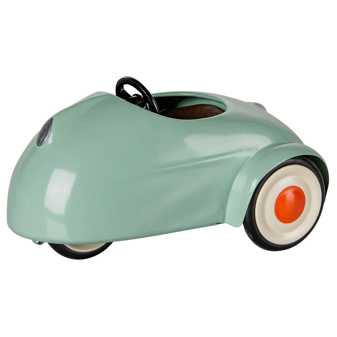 Maileg lichtgroene speelauto met zwart stuur en oranje wielen.
