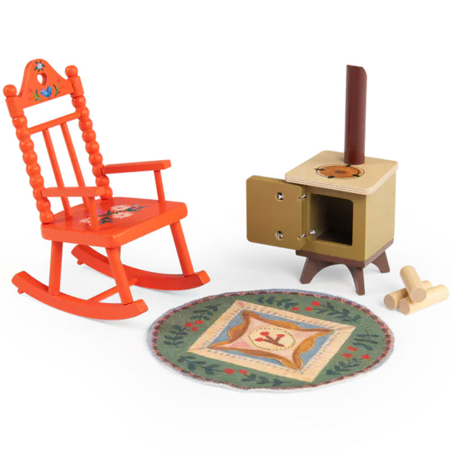 Moulin Roty poppenwoonkamerset met oranje schommelstoel, kachel en rond vloerkleed.