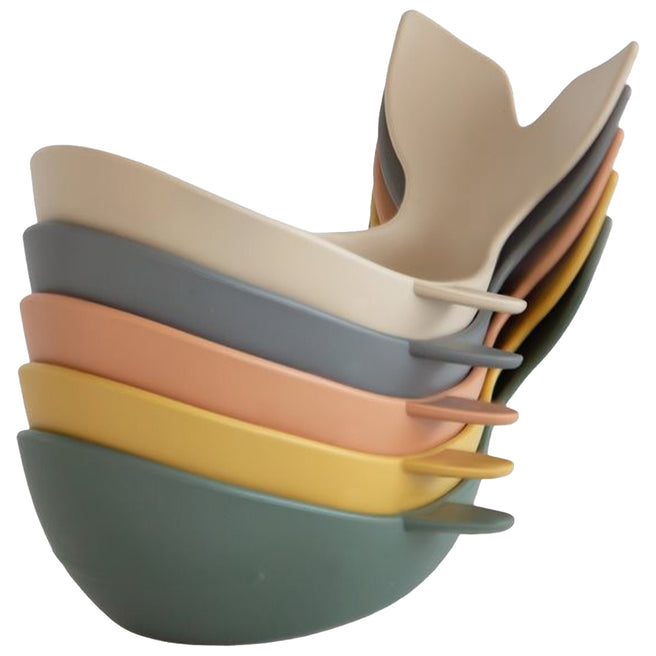 Een stapel Mushie badspeeltjes in de vorm van walvissen in vijf retro kleuren.