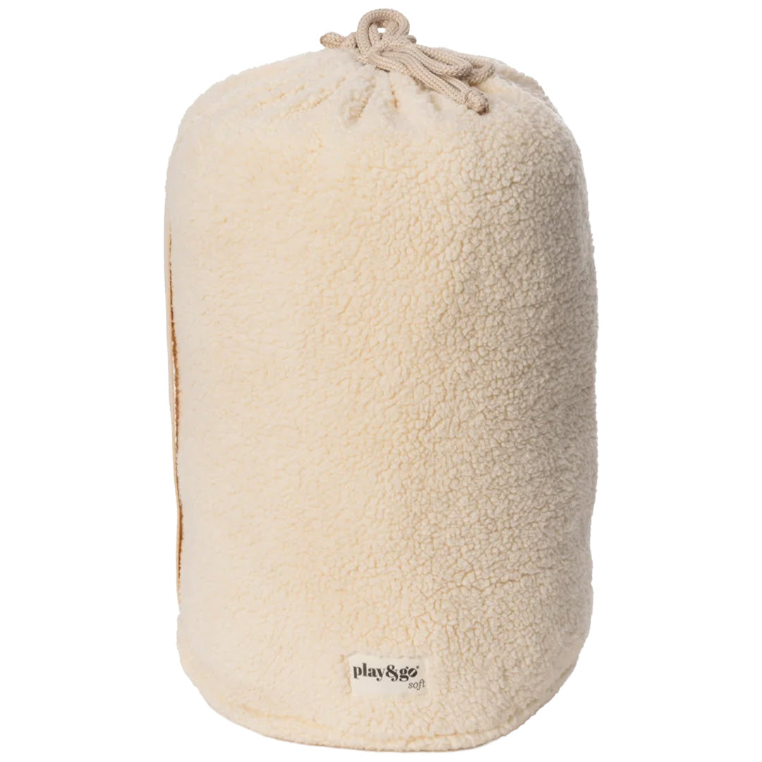 De play&go babyspeelkleed tas in beige teddy stof, opgevouwen tot een cilinder met trekkoord.